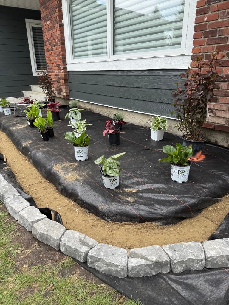 Worker planting and installing weed barrier and edging