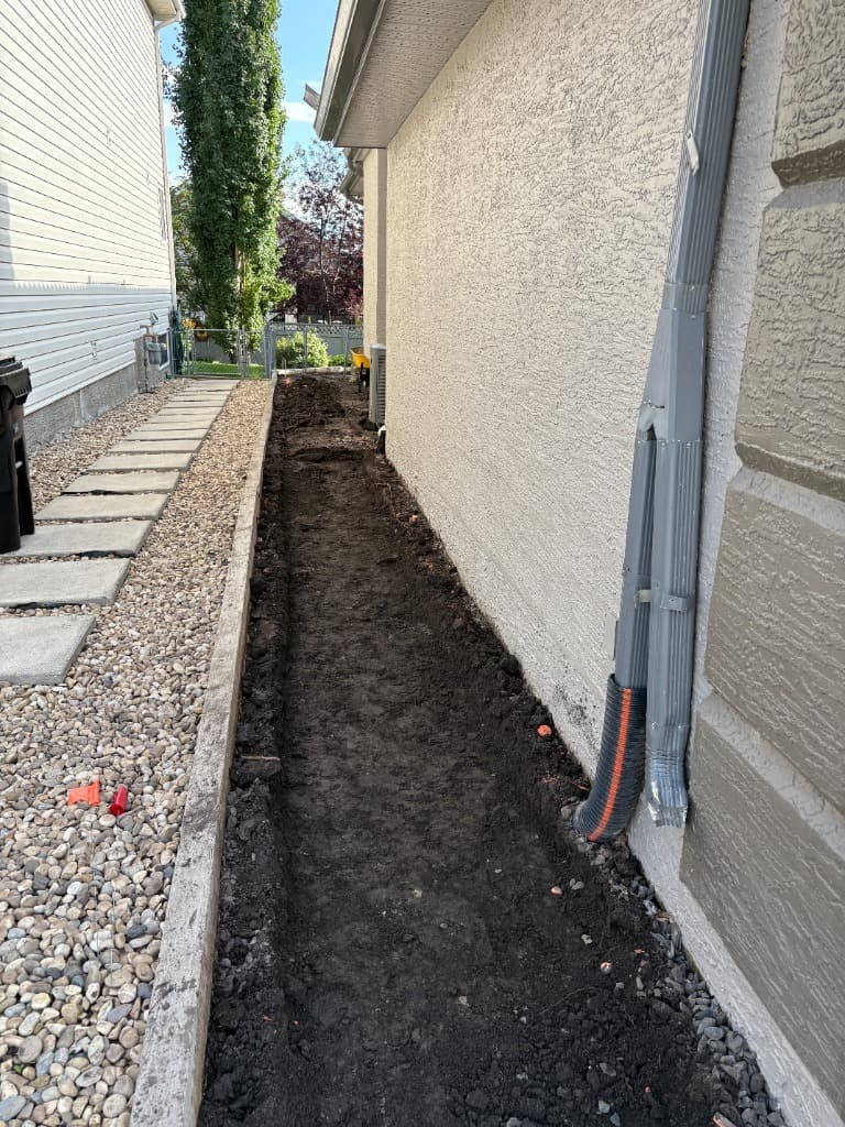 Worker adjusting base prep next to house
